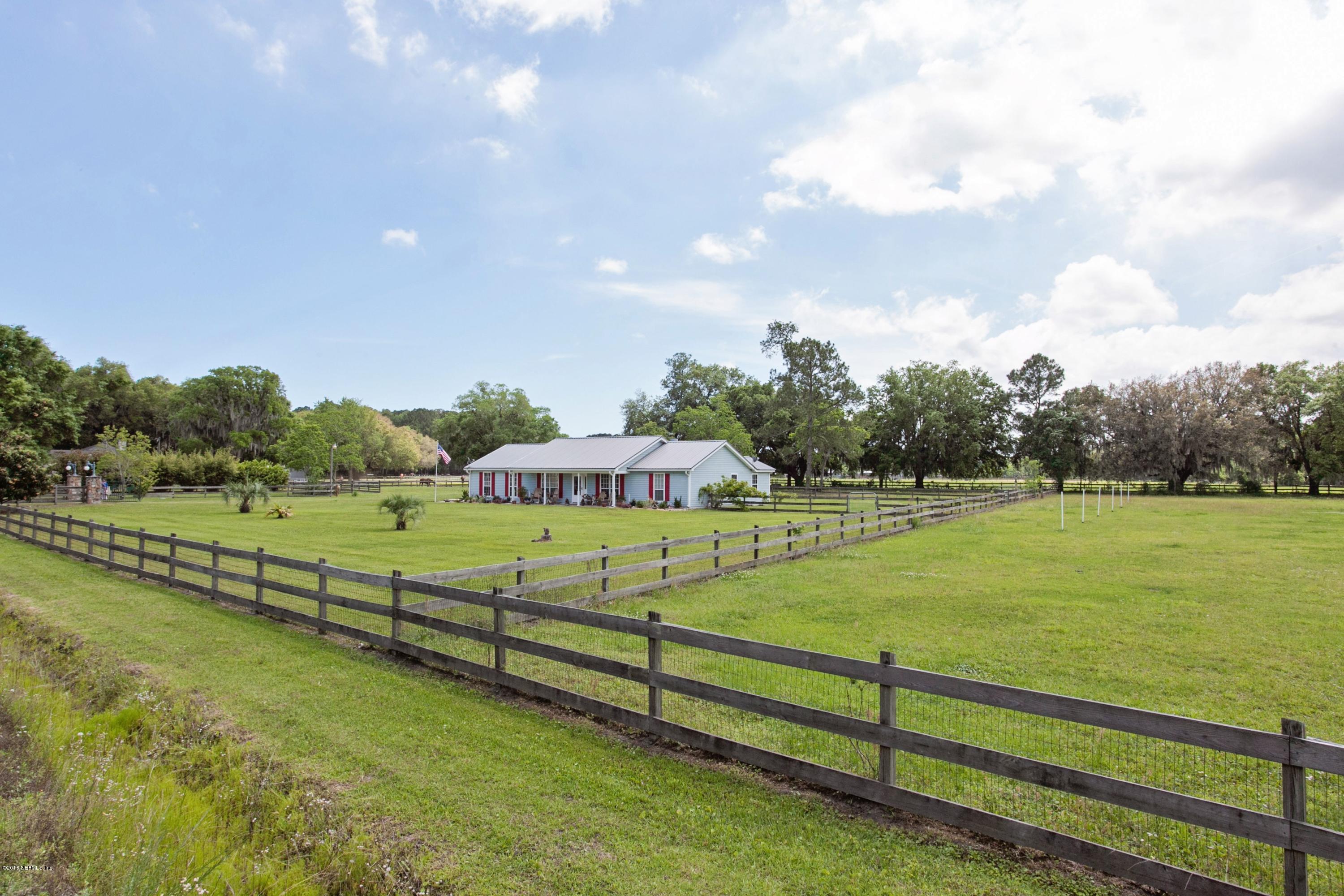4735 Wolfe Road St. Augustine, FL 32092 - Photo 4 of 39 a view of a green field with wooden fence