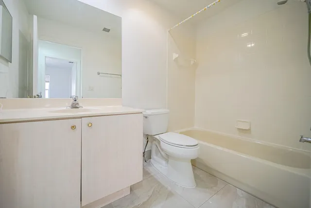 an empty room with windows and chandelier fan