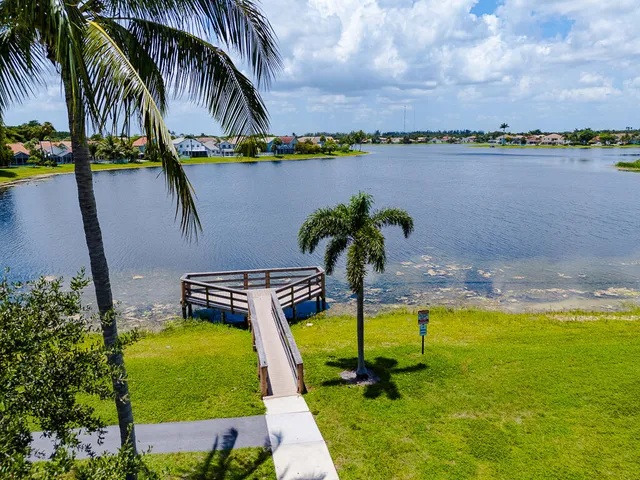 a view of a swimming pool with lawn chairs and plants