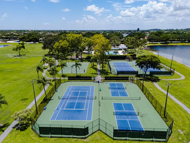 an aerial view of a residential houses with outdoor space and lake view