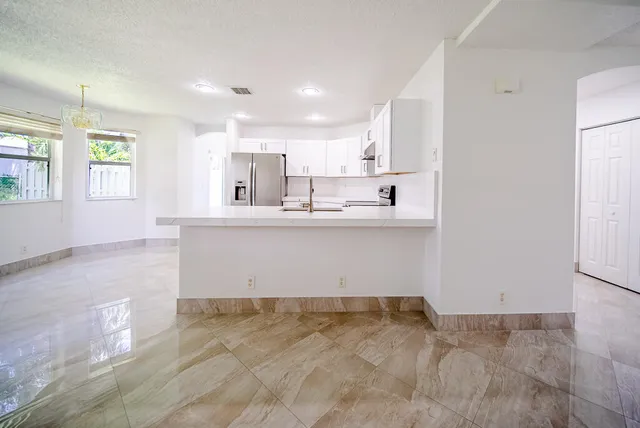 a kitchen with cabinets appliances and a window