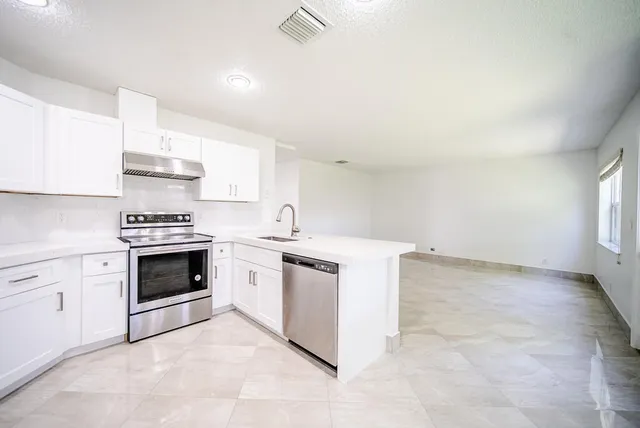 a kitchen with stainless steel appliances a refrigerator sink and stove