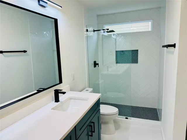 a bathroom with a sink a toilet and shower
