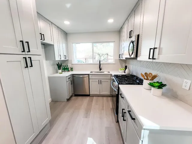 a kitchen with white cabinets and white appliances