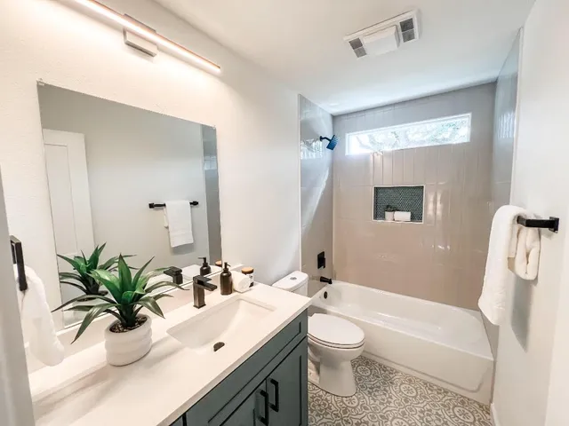 a bathroom with a double vanity sink toilet and a mirror