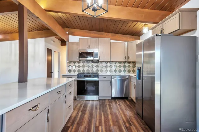a kitchen with kitchen island granite countertop a sink cabinets and stainless steel appliances