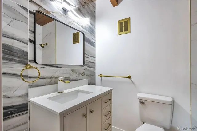 a bathroom with a sink mirror vanity and toilet