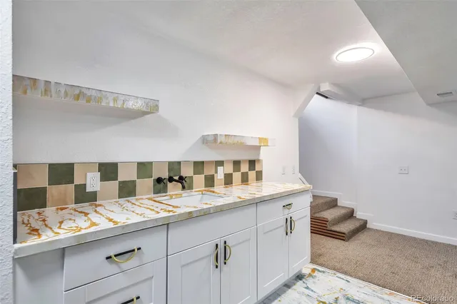 a bathroom with a granite countertop sink and a mirror