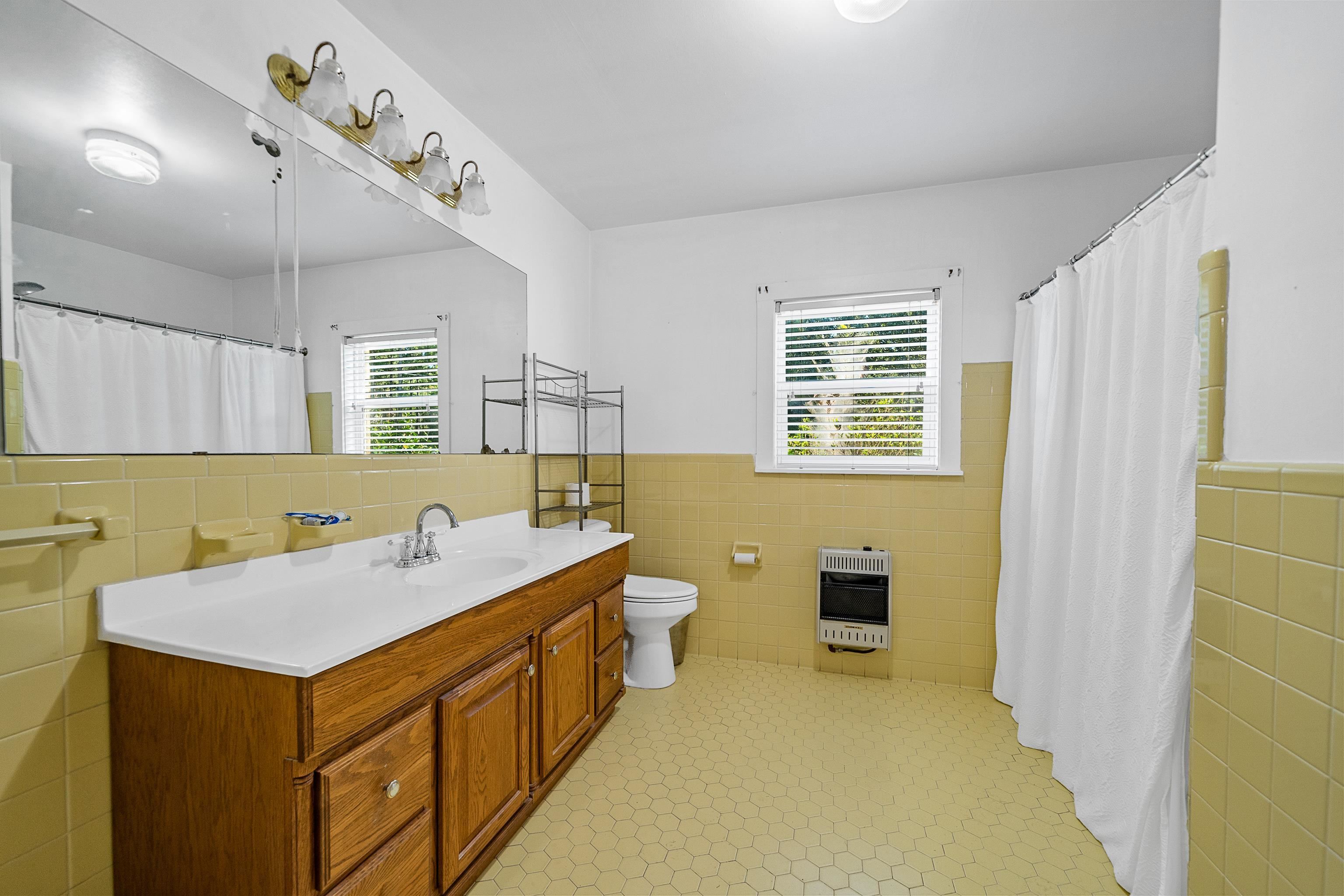 9350 Tompkins Road Stockton, AL 36579 - Photo 22 of 36 Bathroom featuring tile walls, wainscoting, vanity, heating unit, and a shower with curtain