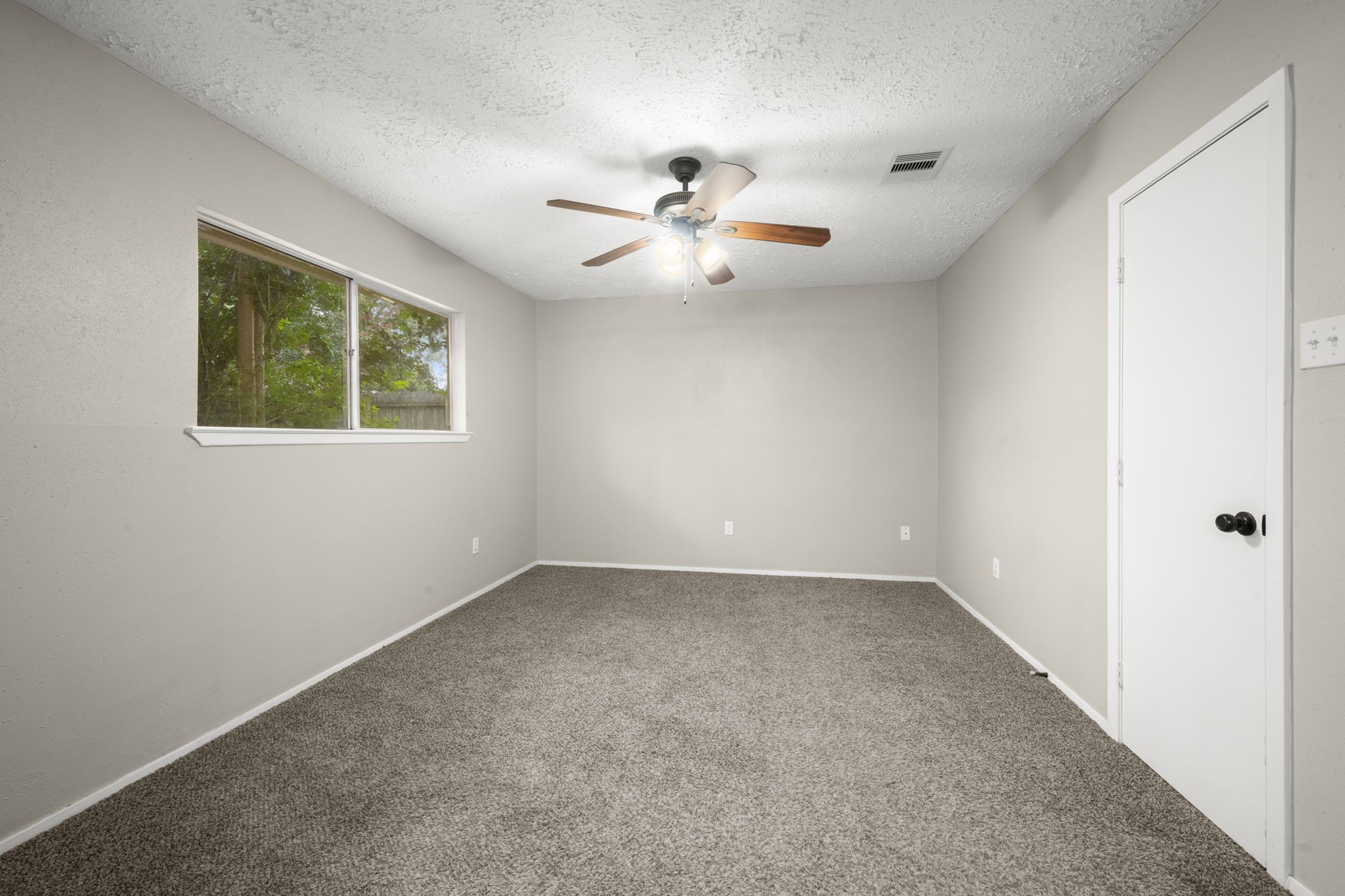 14219 Jaquine Drive Cypress, TX 77429 - Photo 13 of 16 an empty room with windows and fan