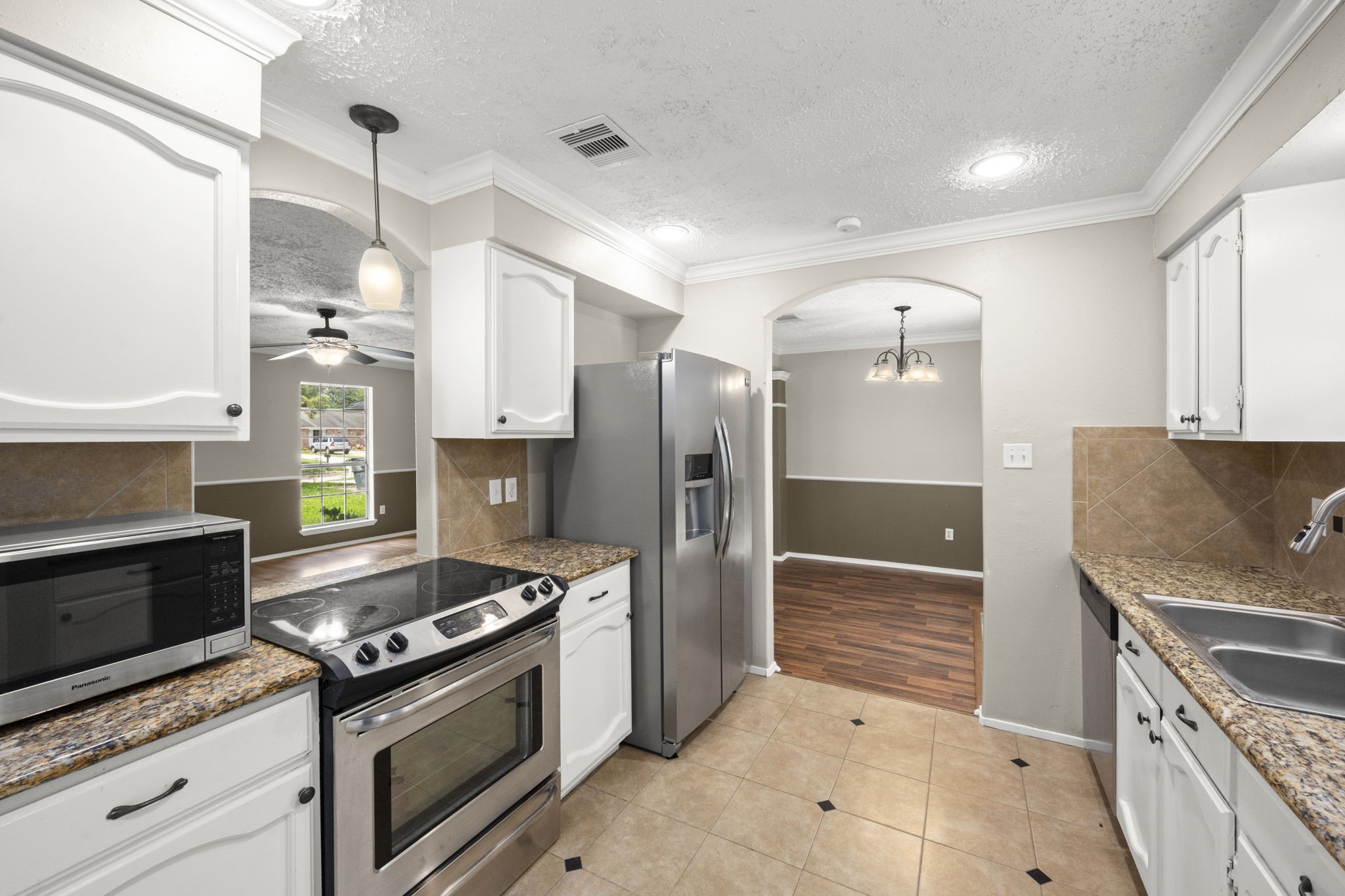 14219 Jaquine Drive Cypress, TX 77429 - Photo 7 of 16 a kitchen with stainless steel appliances granite countertop a stove and a refrigerator