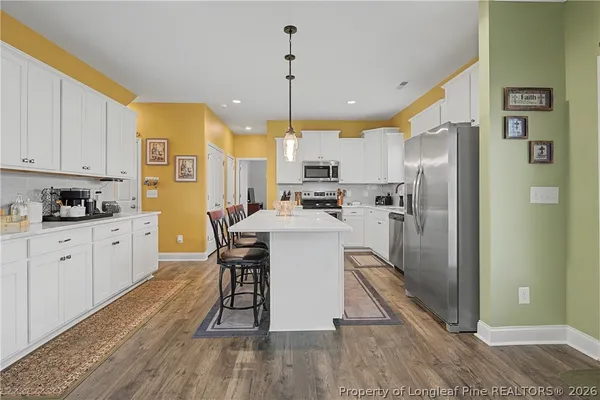a kitchen with kitchen island a counter top space appliances and cabinets