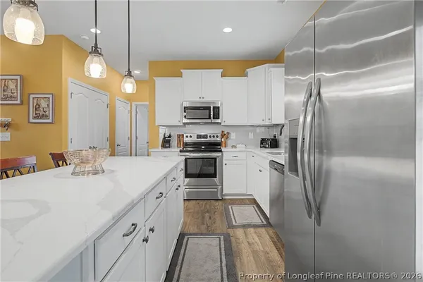 a kitchen with stainless steel appliances granite countertop table chairs sink and cabinets