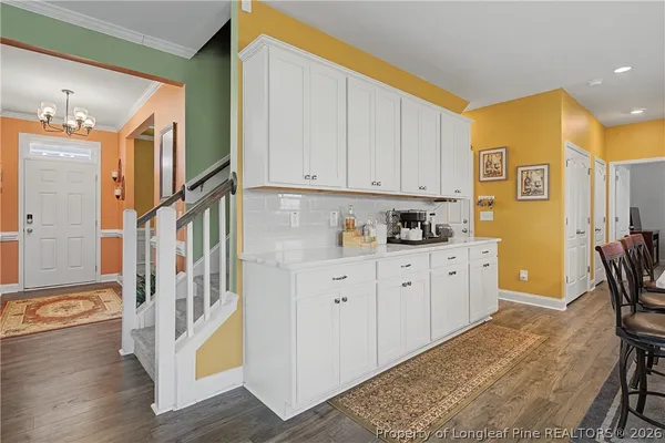 a kitchen with stainless steel appliances a dining table chairs a sink a refrigerator and a window