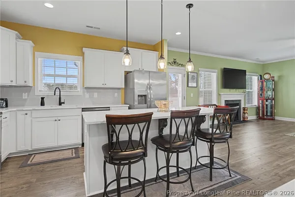 a kitchen with stainless steel appliances granite countertop white cabinets sink and a granite counter top