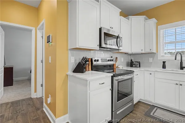 a spacious bedroom with a bed a chandelier and a dresser