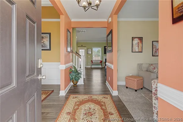 a view of a dining room with furniture and a chandelier