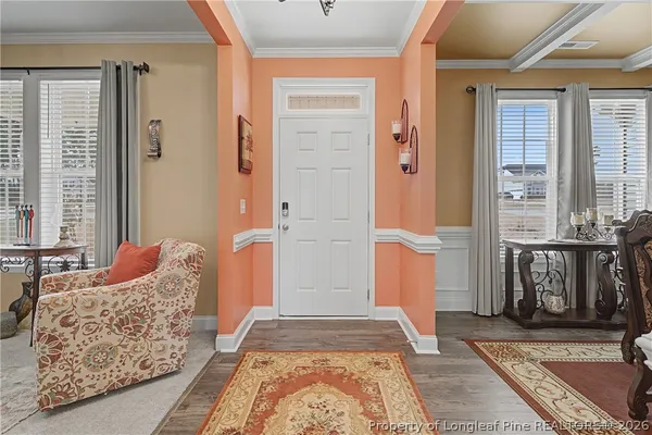 a view of a dining room with furniture a rug and wooden floor
