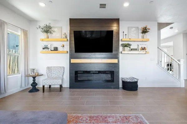 a spacious bedroom with a bed a couch and a chandelier