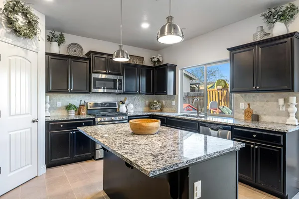 a kitchen with stainless steel appliances granite countertop a sink stove and refrigerator