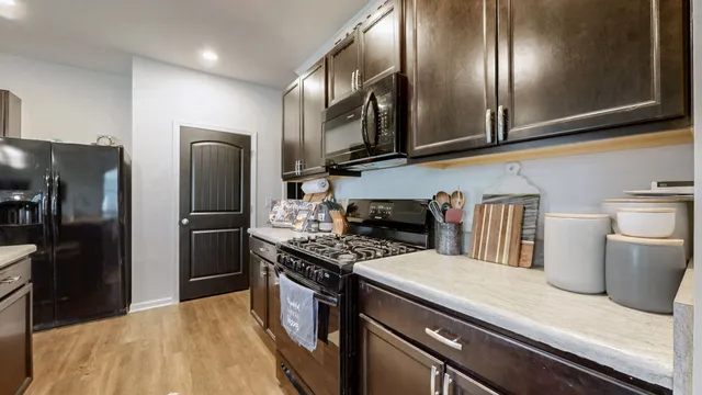 a kitchen with stainless steel appliances granite countertop a refrigerator a stove and a sink