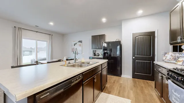 a kitchen with stainless steel appliances granite countertop a sink stove and refrigerator