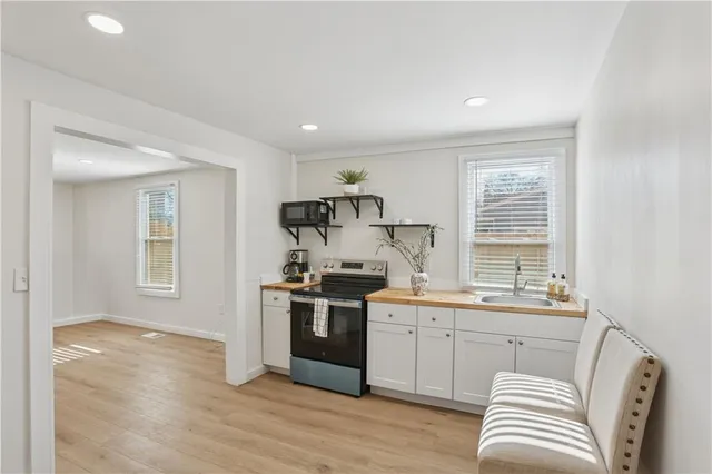 a kitchen with stainless steel appliances granite countertop a sink stove and wooden floor