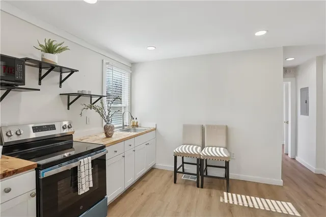 a kitchen with a stove and a wooden floor