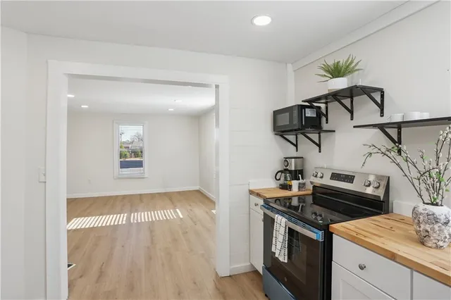 a kitchen with a stove and a wooden floor