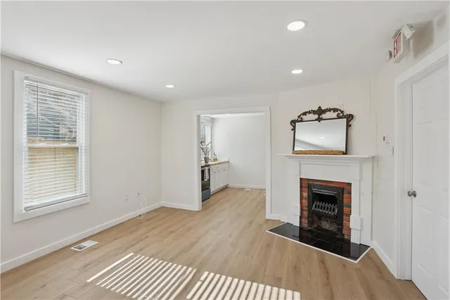 a view of an empty room with a fireplace and a window