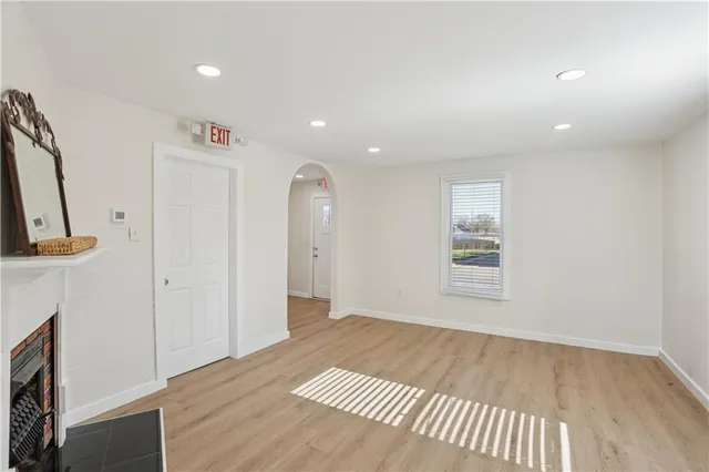 an empty room with wooden floor and a fireplace