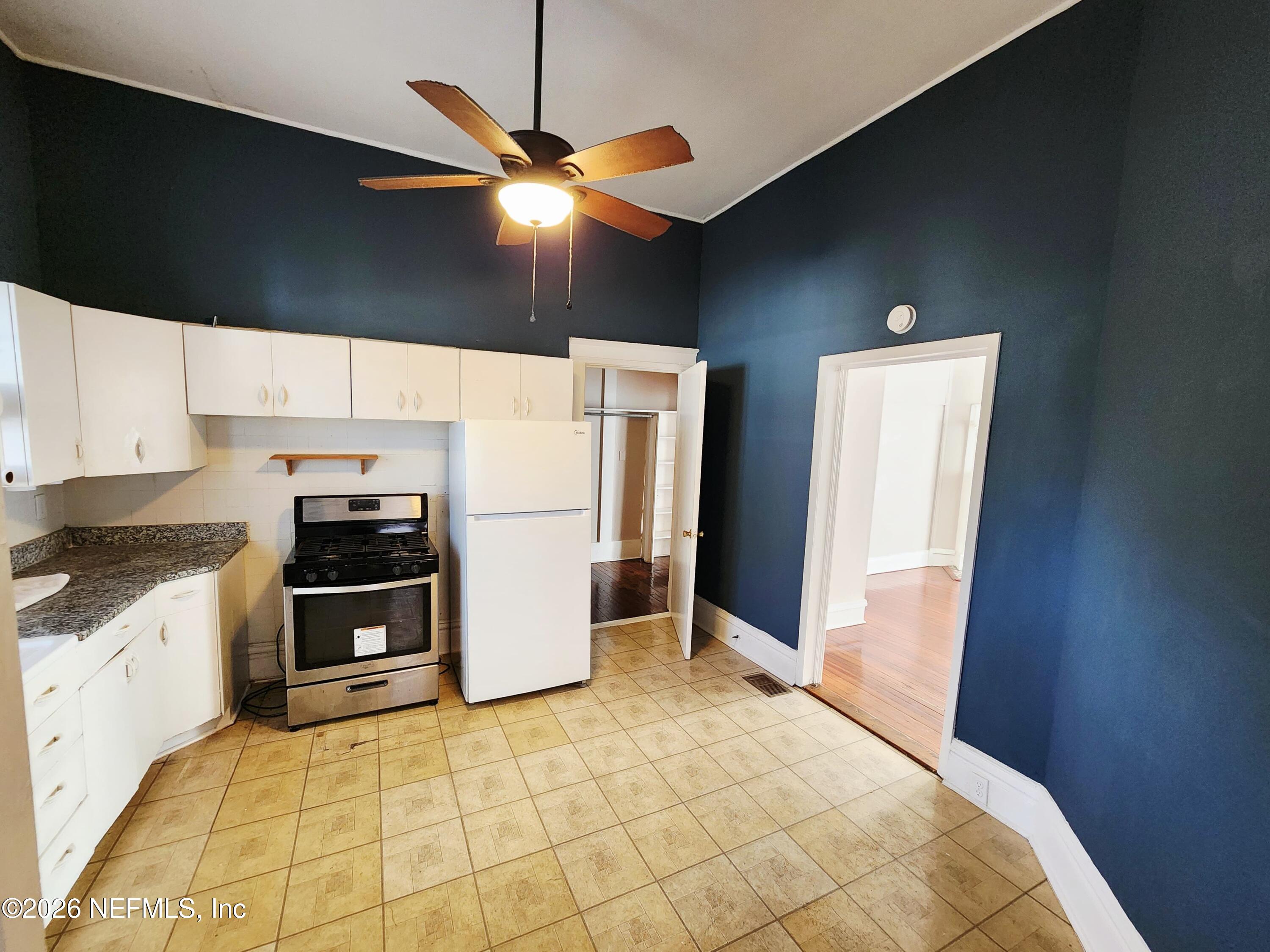 1719 Aberdeen Street Jacksonville, FL 32205 - Photo 9 of 17 a kitchen with stainless steel appliances a refrigerator a stove a microwave oven with cabinets and wooden floor