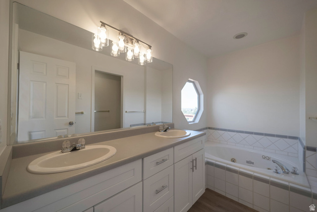 11922 Bluff View Drive Sandy, UT 84092 - Photo 15 of 30 Full bath with double vanity, dark wood-type flooring, and a jetted tub