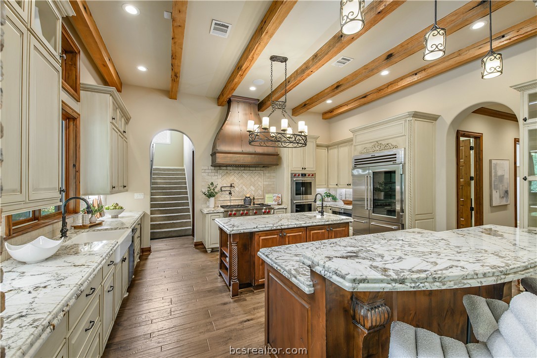 4207 Tuscany Court Bryan, TX 77802 - Photo 16 of 46 a large kitchen with kitchen island a sink table and chairs