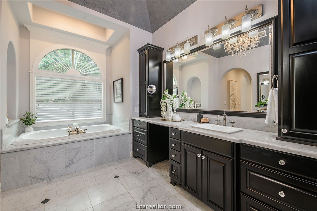4207 Tuscany Court Bryan, TX 77802 - Photo 27 of 46 a spacious bathroom with a granite countertop sink mirror and a bathtub