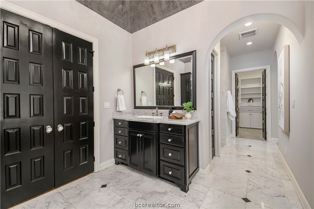 4207 Tuscany Court Bryan, TX 77802 - Photo 30 of 46 a spacious bathroom with a double vanity sink and a mirror