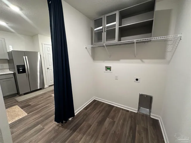 a view of a hallway with wooden floor and a cabinet