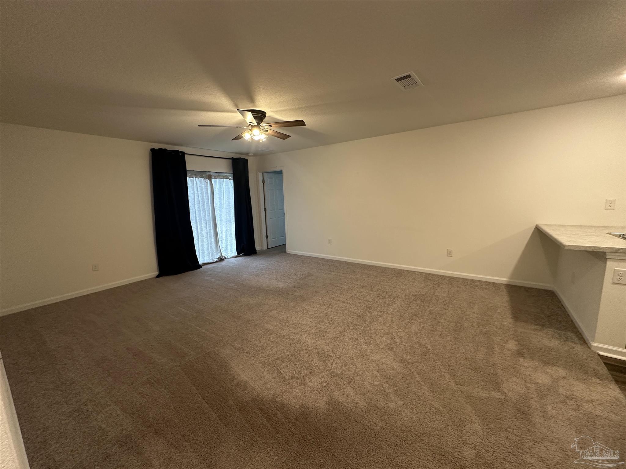 8752 Schooner Lane Pensacola, FL 32507 - Photo 2 of 13 a view of a big room with windows and chandelier fan