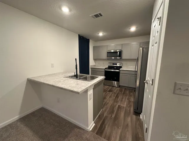 a kitchen with a sink stove and refrigerator