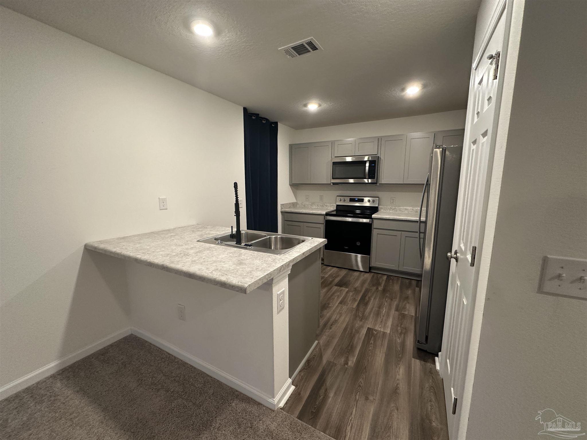 8752 Schooner Lane Pensacola, FL 32507 - Photo 3 of 13 a kitchen with a sink stove and refrigerator
