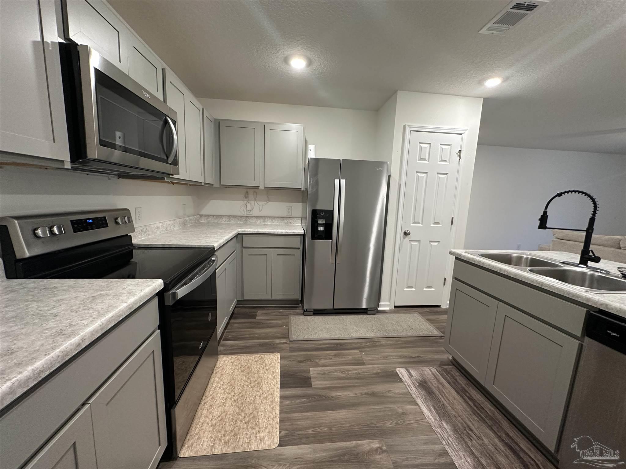 8752 Schooner Lane Pensacola, FL 32507 - Photo 4 of 13 a kitchen with stainless steel appliances granite countertop a sink stove and refrigerator