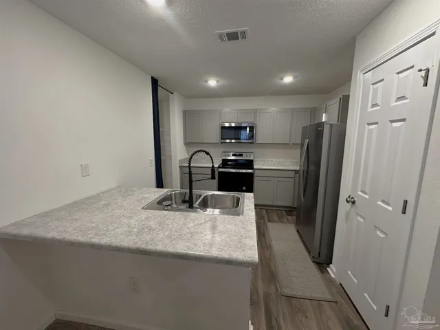 a kitchen with refrigerator cabinets and a sink