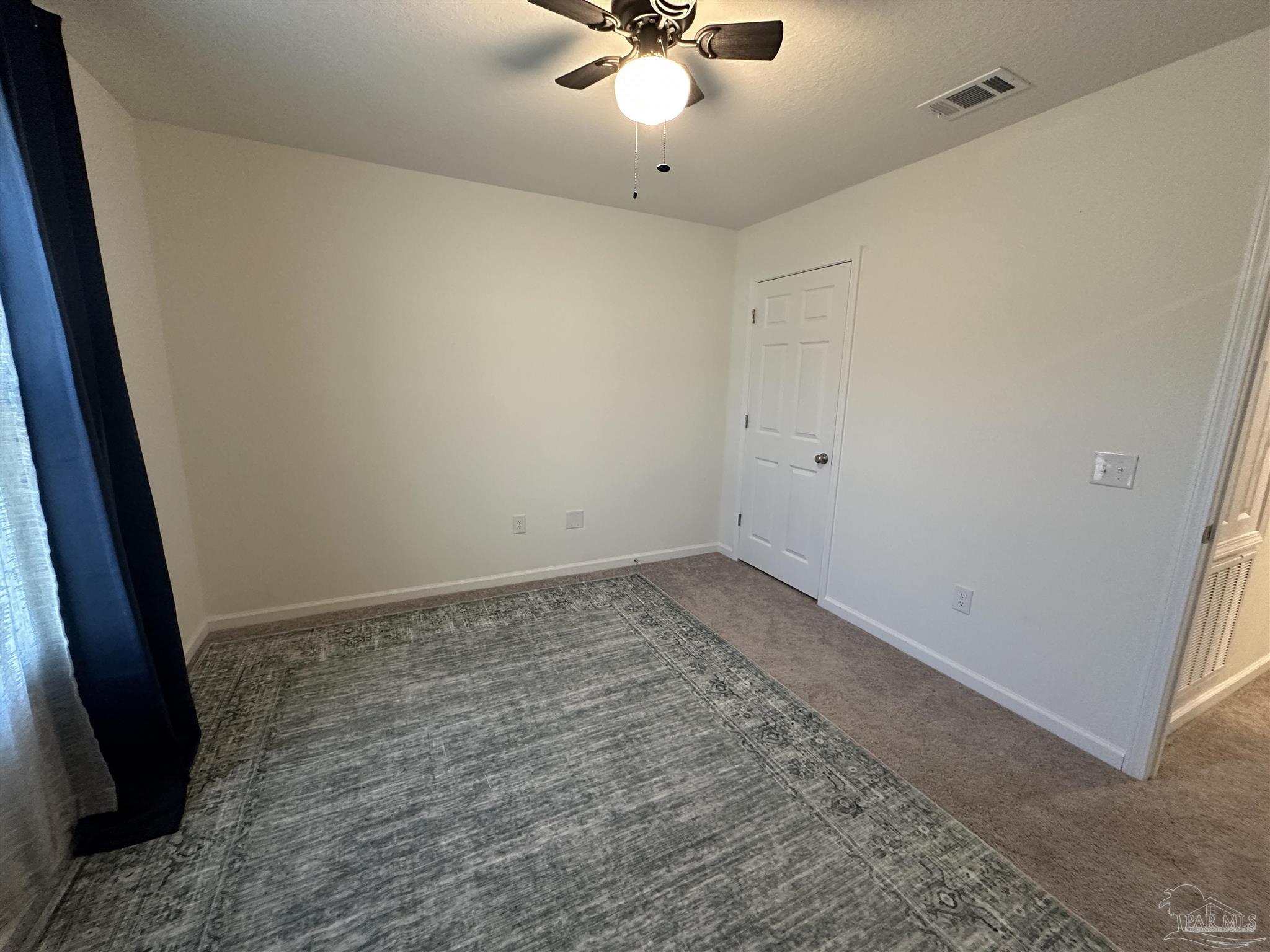 8752 Schooner Lane Pensacola, FL 32507 - Photo 9 of 13 an empty room with a ceiling fan and carpet
