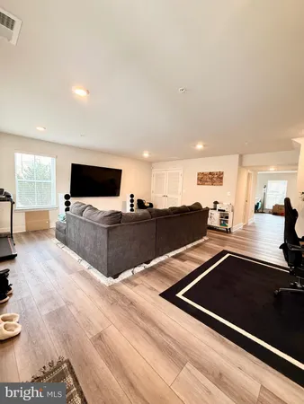 a living room with stainless steel appliances furniture and a flat screen tv