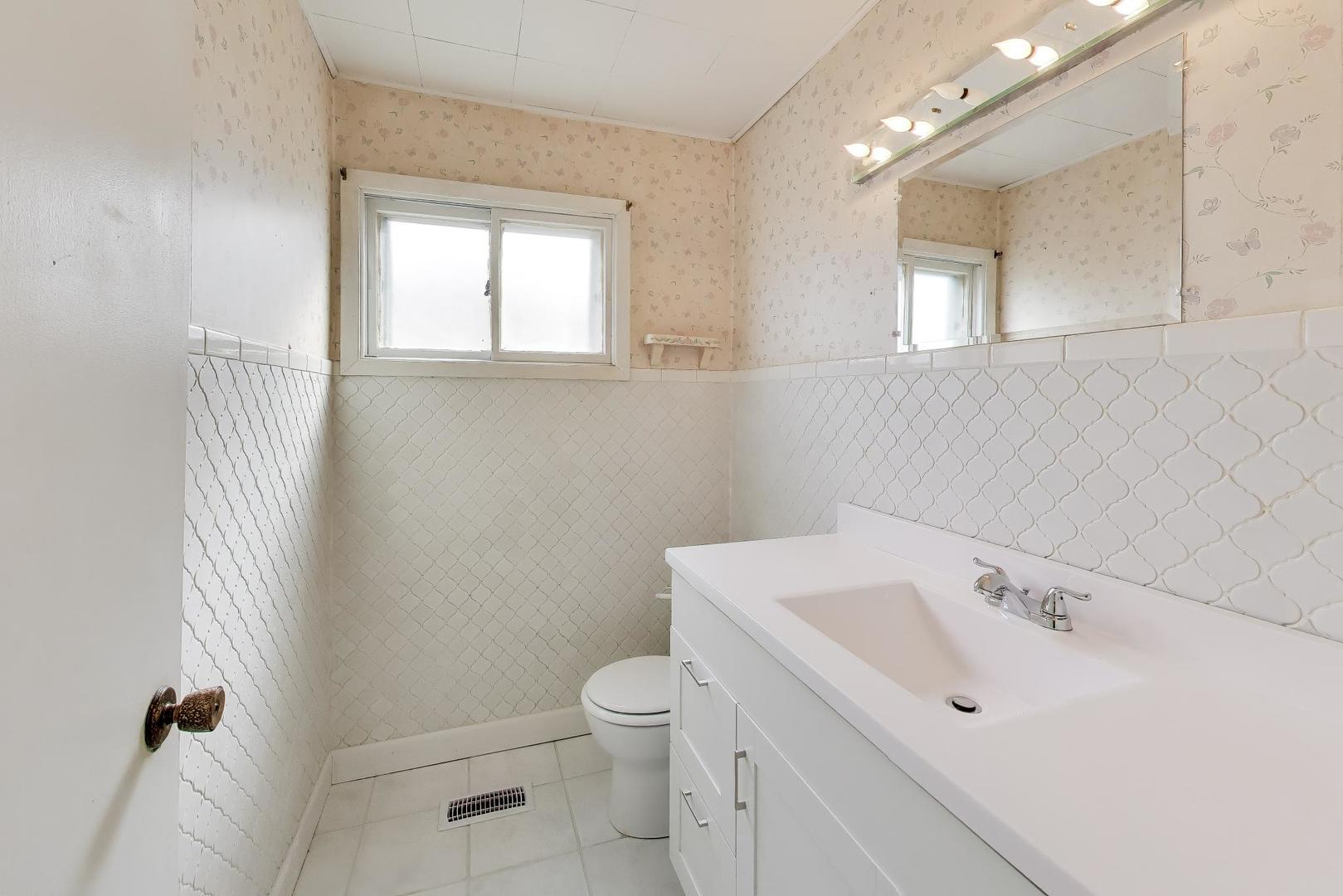 2703 North Ridge Avenue Arlington Heights, IL 60004 - Photo 22 of 51 a bathroom with a sink a toilet and a mirror