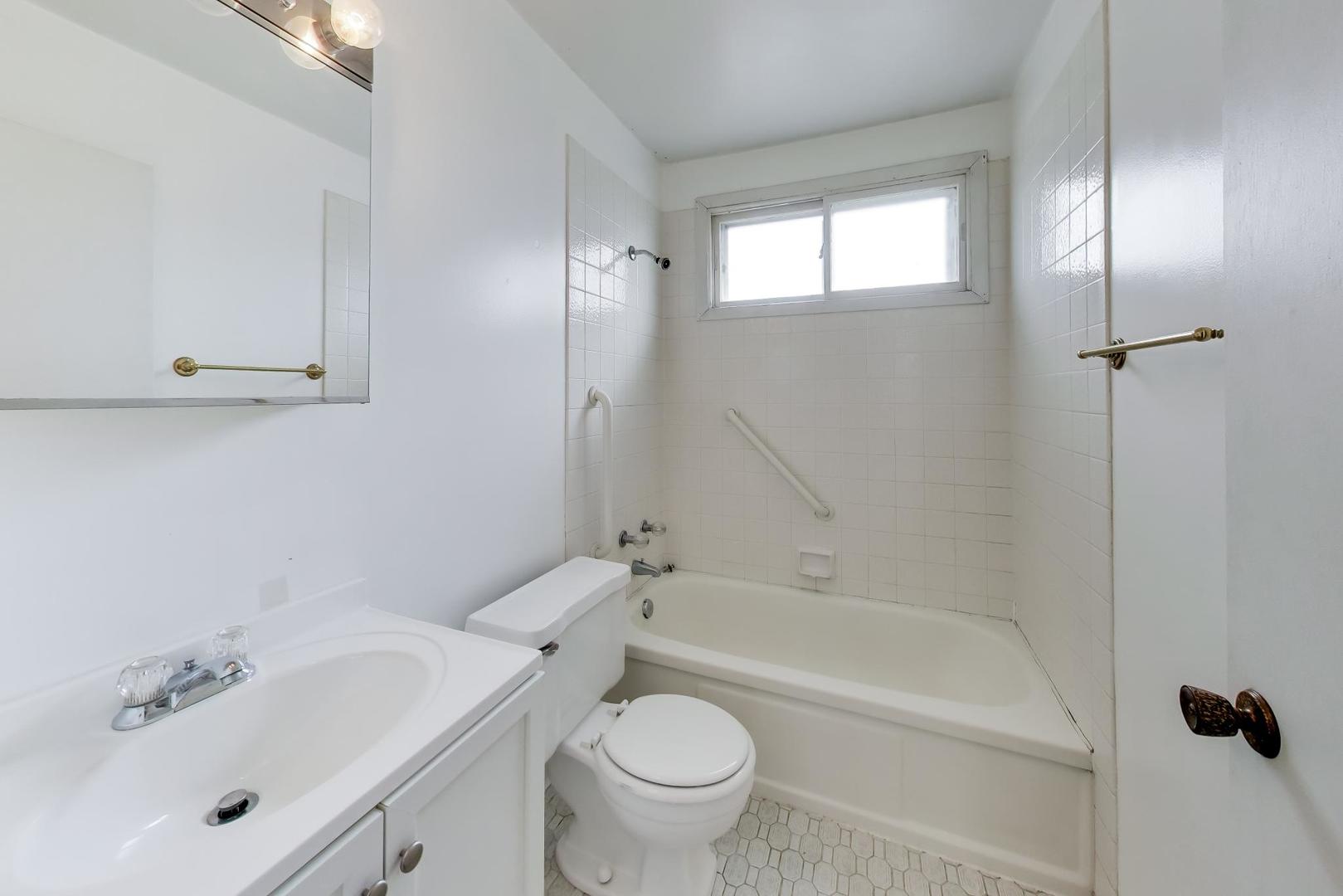 2703 North Ridge Avenue Arlington Heights, IL 60004 - Photo 37 of 51 a bathroom with a bathtub shower sink vanity and toilet