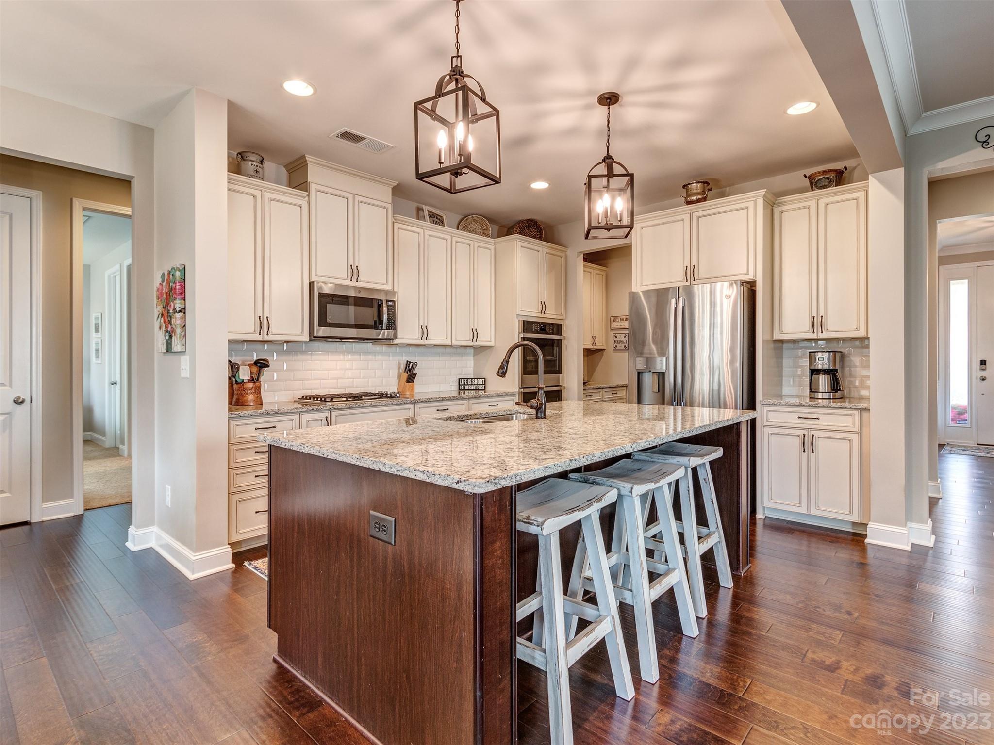 5515 Braddock Ml Way Lancaster, SC 29720 - Photo 12 of 41 a kitchen with stainless steel appliances kitchen island granite countertop a refrigerator a stove a sink and a dining table with wooden floor