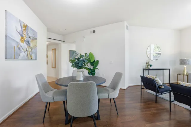 a dining room with furniture potted plants and wooden floor