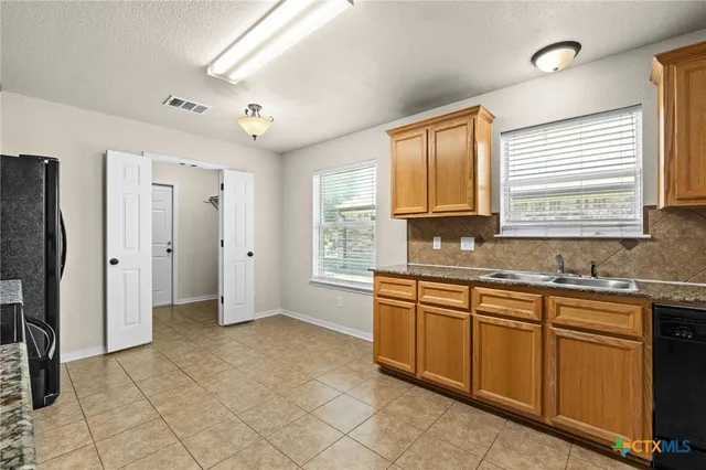 a spacious bathroom with a granite countertop sink a mirror and a bathtub
