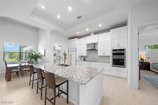 a kitchen with kitchen island granite countertop lots of counter top and refrigerator